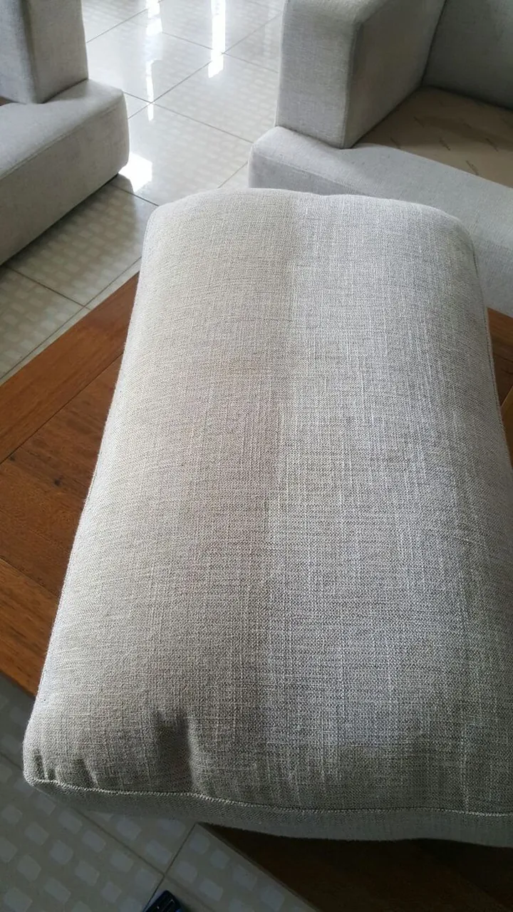 Fabric ottoman with a clean half and a soiled half after one cleaning pass